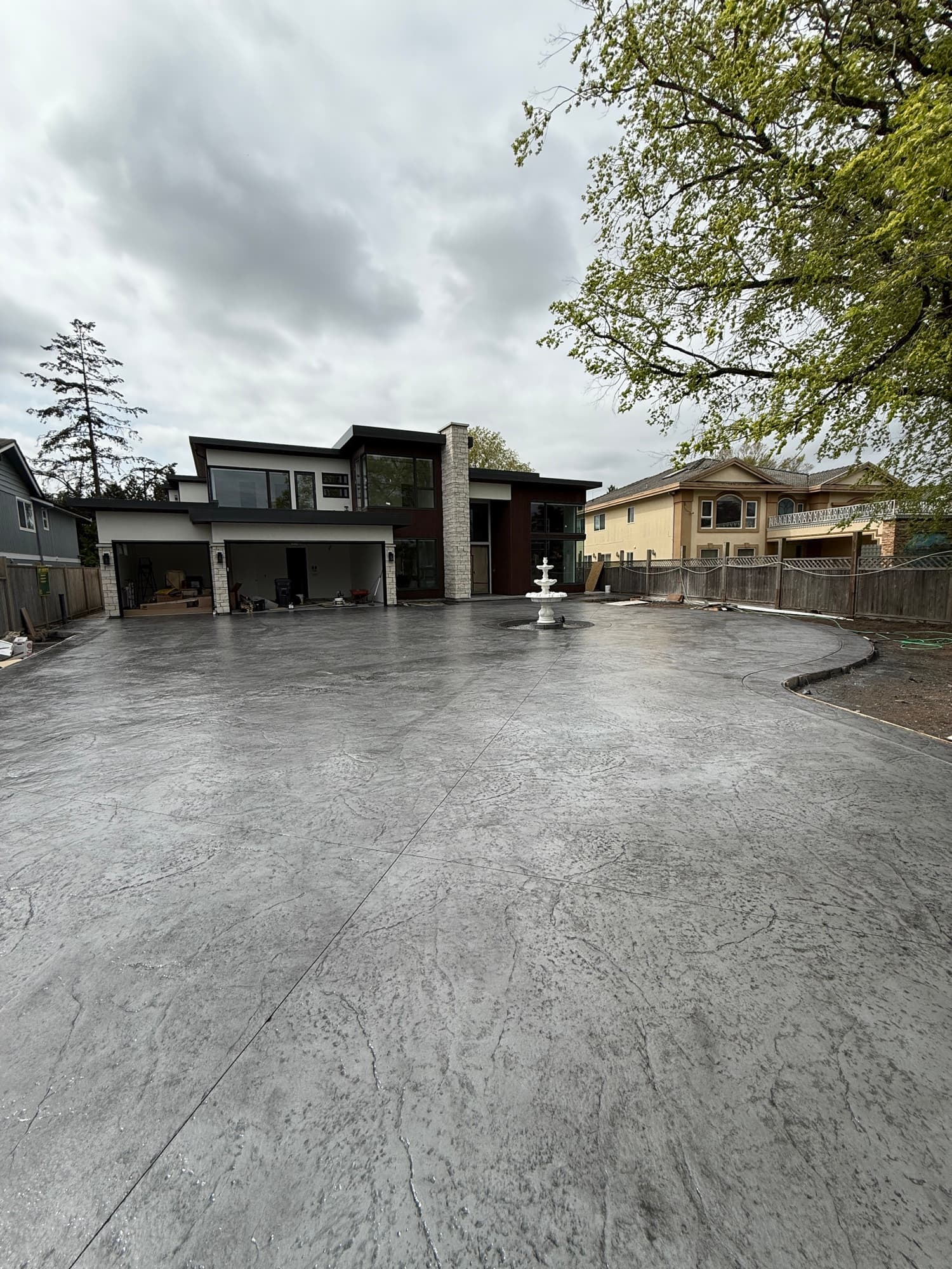 The same courtyard after sealing — deep charcoal tone with a wet-look shine