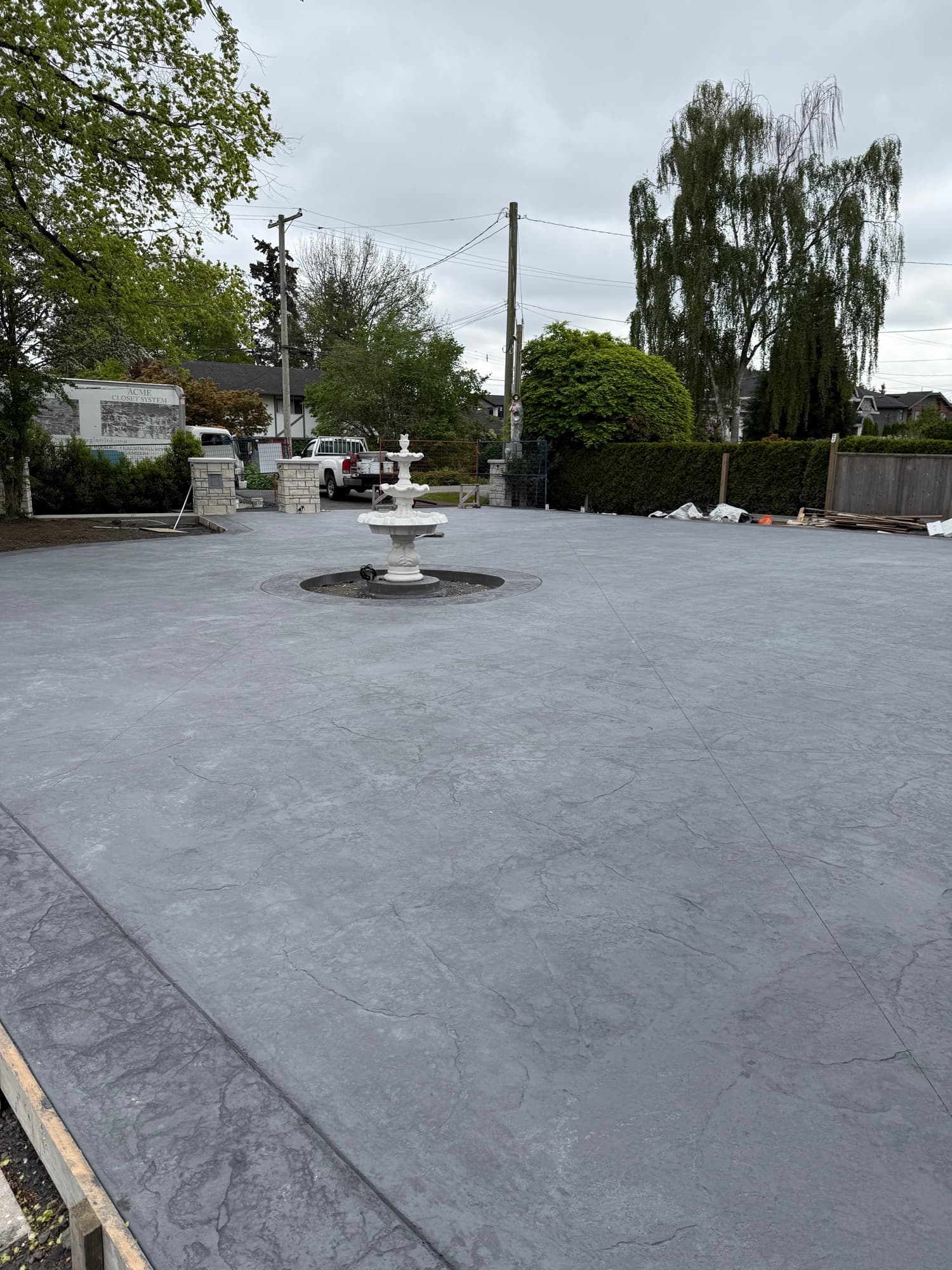 Freshly stamped concrete courtyard with a fountain centerpiece — finished and stamped, before washing and sealing